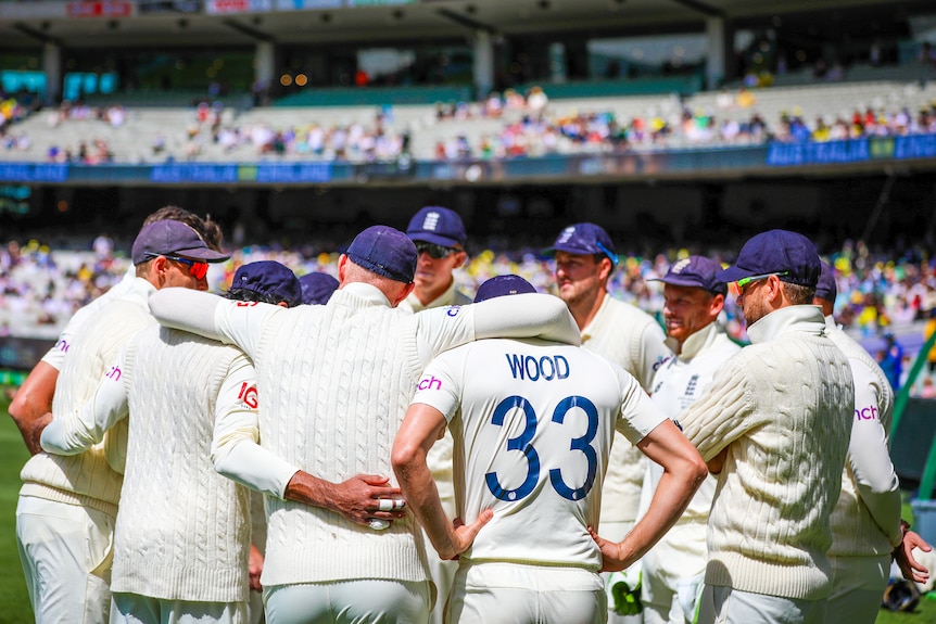 The English cricket team stand in a circle with their arms around each other