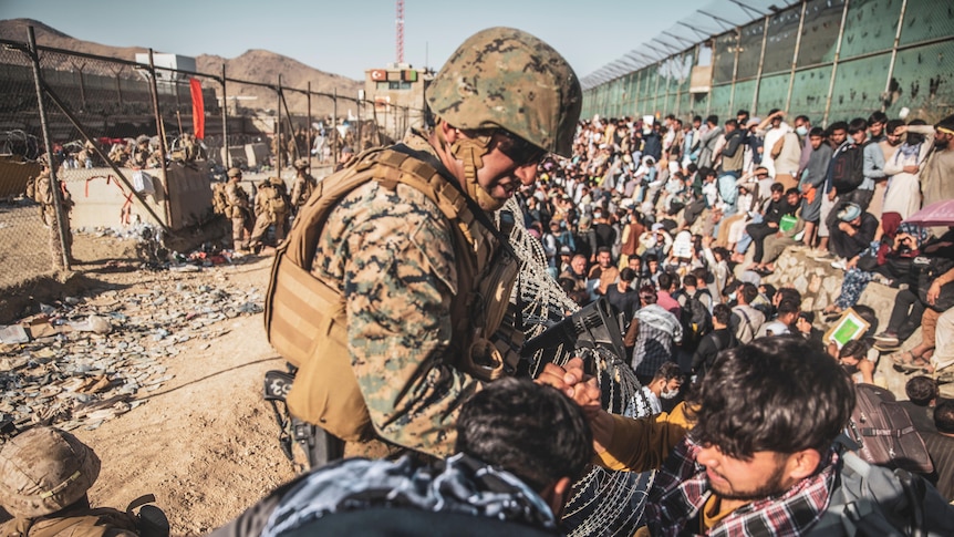 A US marine helps an evacuee among the crowd at Kabul's international airport