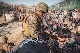 A US marine helps an evacuee among the crowd at Kabul's international airport