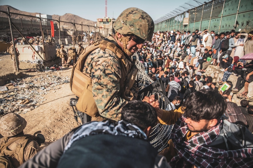 A US marine helps an evacuee among the crowd at Kabul's international airport