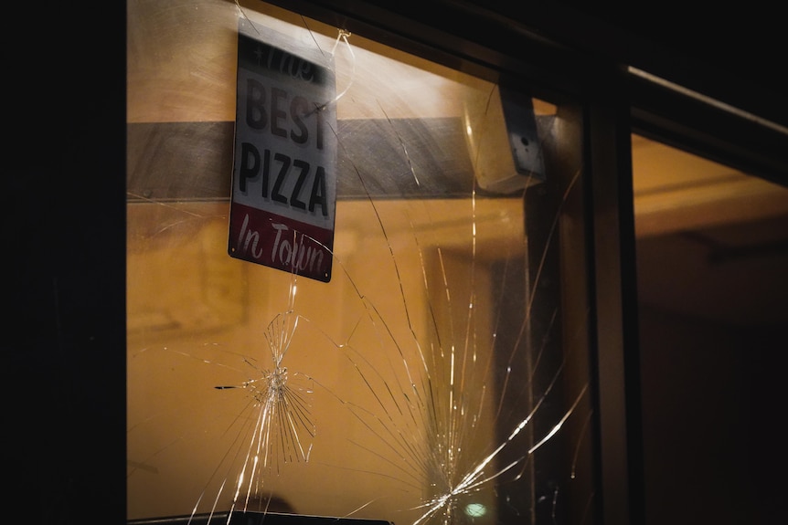 Broken windows at a pizza shop in Alice Springs.
