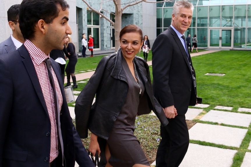 Anne Aly walks alongside colleagues.