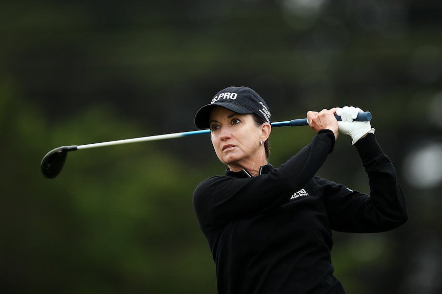Close-up shot of Karrie Webb teeing off during the Vic Open at 13th Beach Golf Club.  She is dressed in black with a black hat