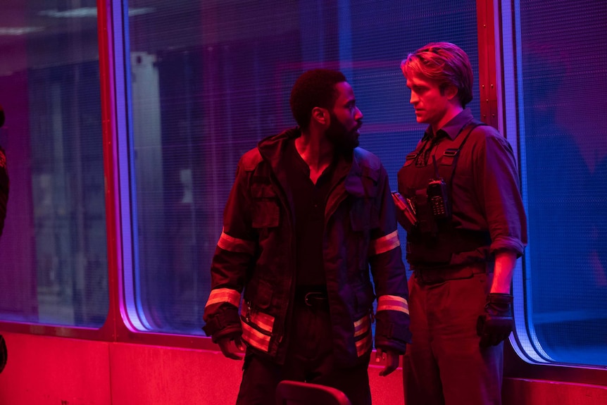 John David Washington and Robert Pattinson confront each other in a scene from the film Tenet