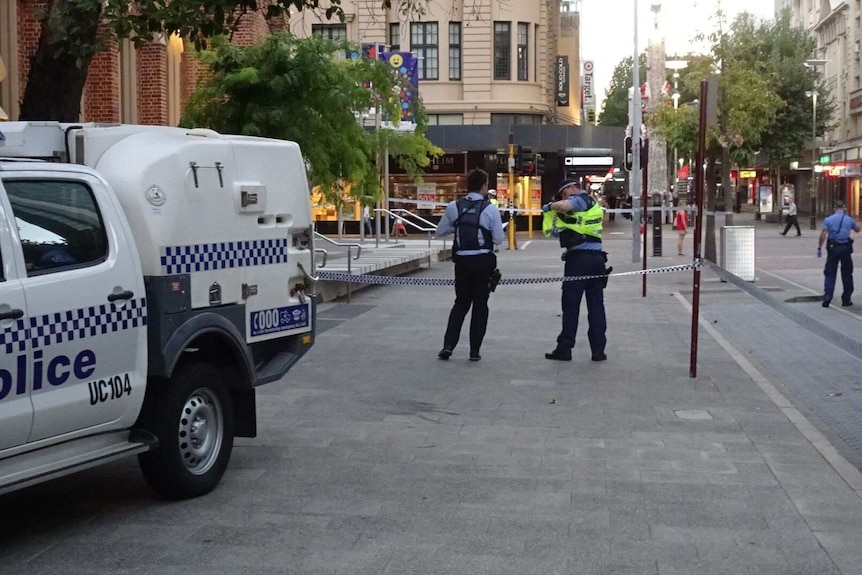 A police car and several policeman in front of police tape in Perth's CBD.