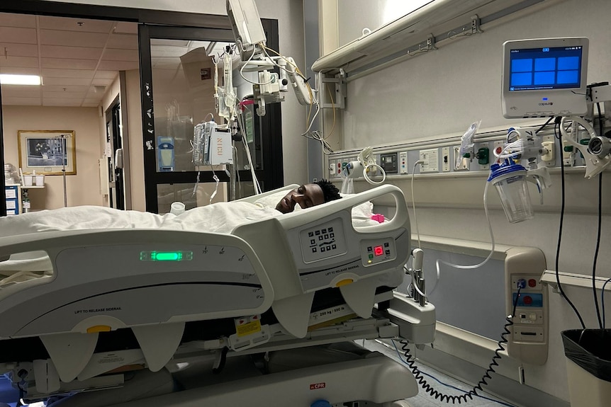 African American young man lying in hospital bed