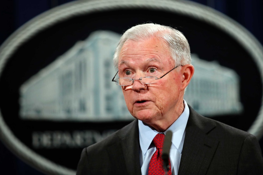 United States Attorney General Jeff Sessions looks over his glasses.