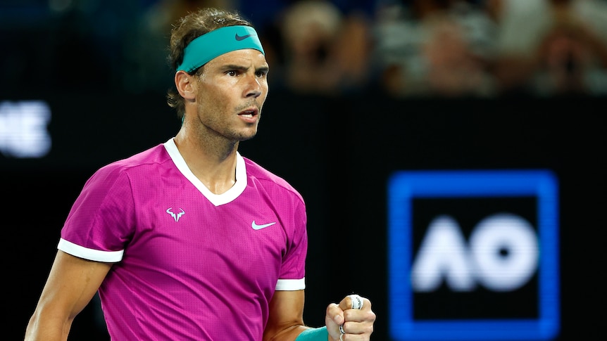 A Spanish male tennis player pumps his left fist as he celebrates winning a point.