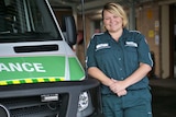 A woman in uniform standing next to an ambulance