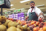 Woolworths staff add fruit to a display