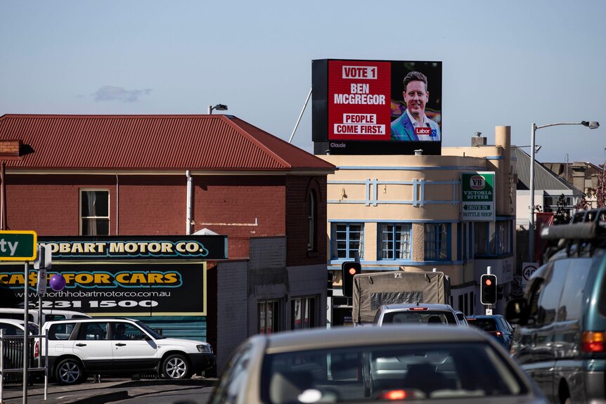 An election billboard on top of a building.