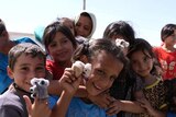 Children in Zaatari refugee camp hold koala toys