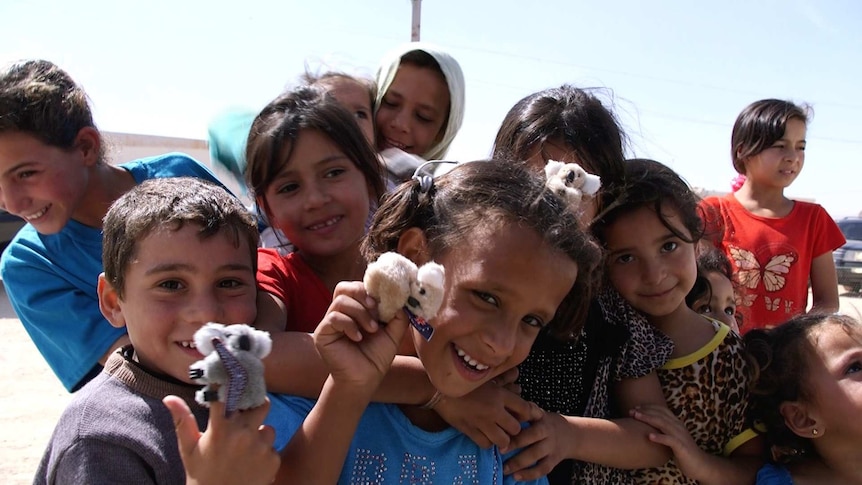 Children in Zaatari refugee camp hold koala toys
