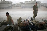 Israeli soldiers rest in a staging area