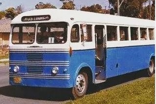 A blue and white bus parked on a suburban street.