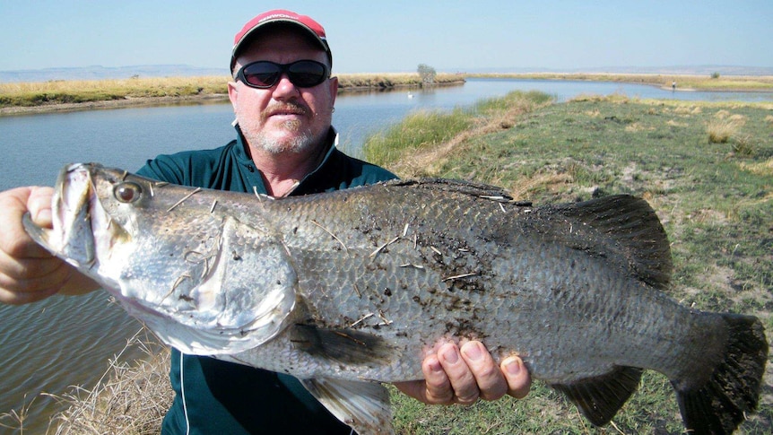 A picture of Craig Butler with a barramundi caught while fishing in the NT.