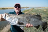 A picture of Craig Butler with a barramundi caught while fishing in the NT.