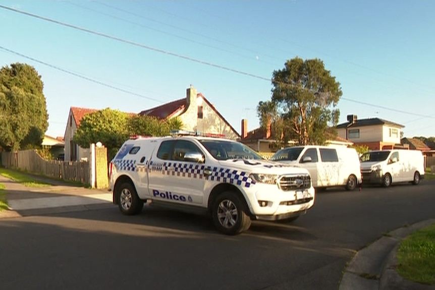 a police car parked across a residential street.