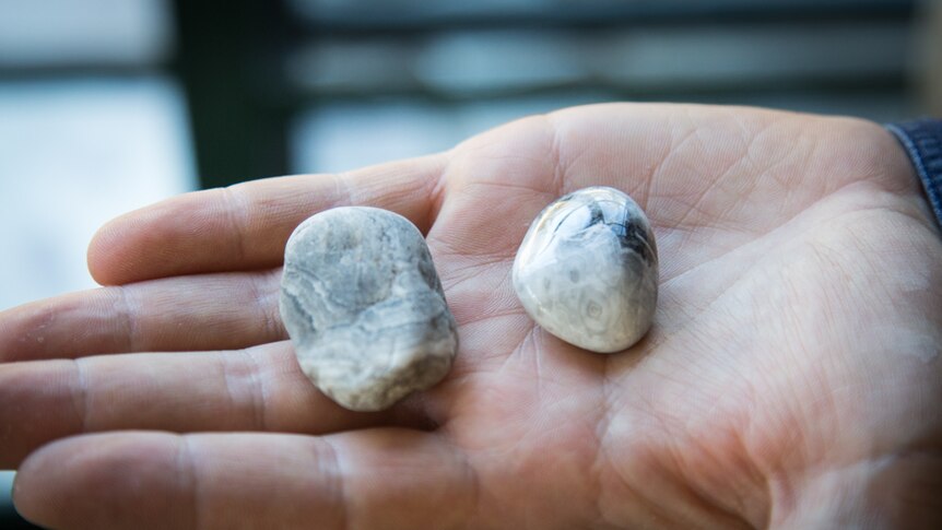 Before and after: an unpolished stone compared to a polished stone shows the contrast in creating the object.