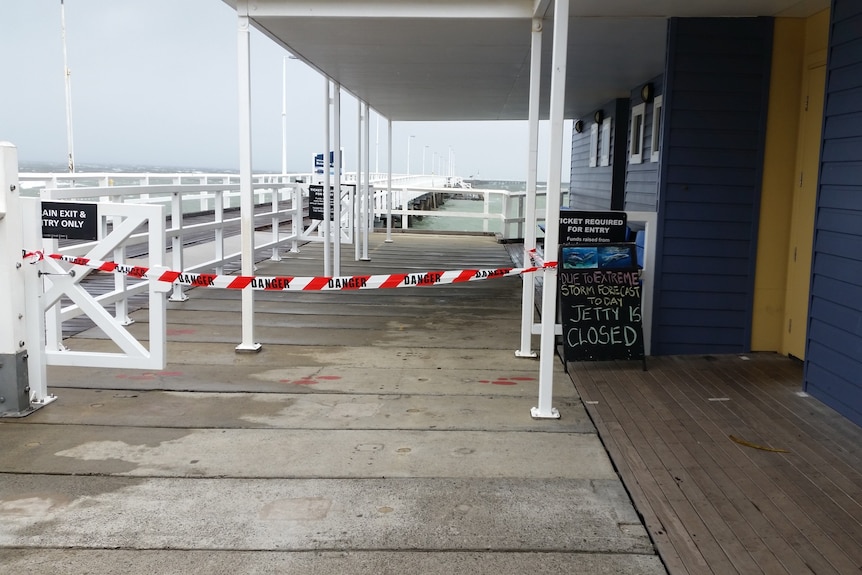 Caution tape blocks the entry to a jetty