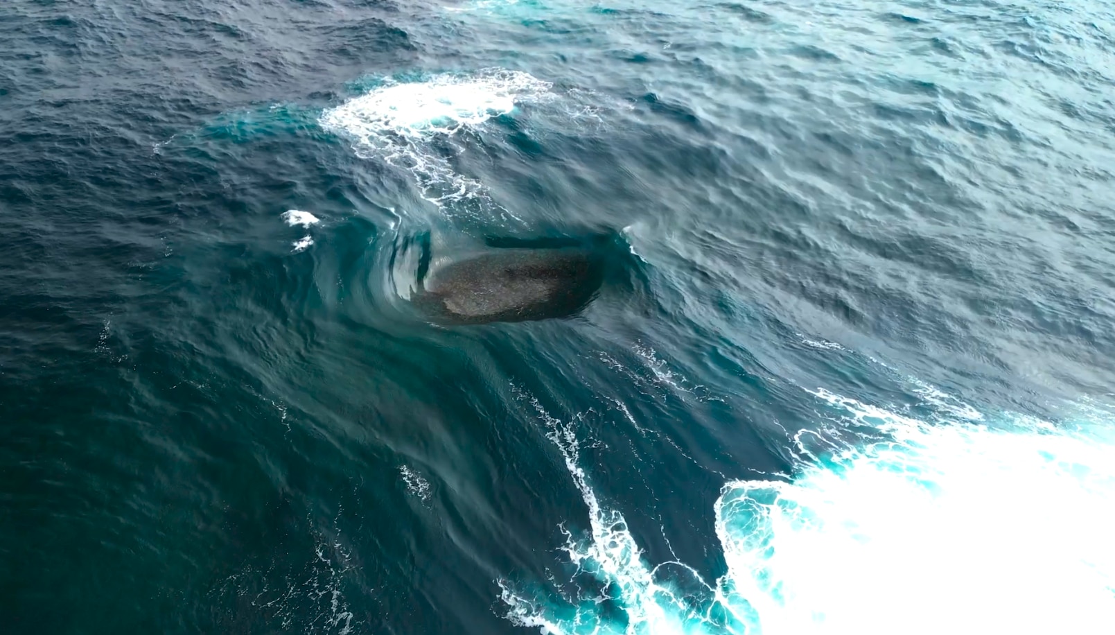 A reef exposed as two waves collide.