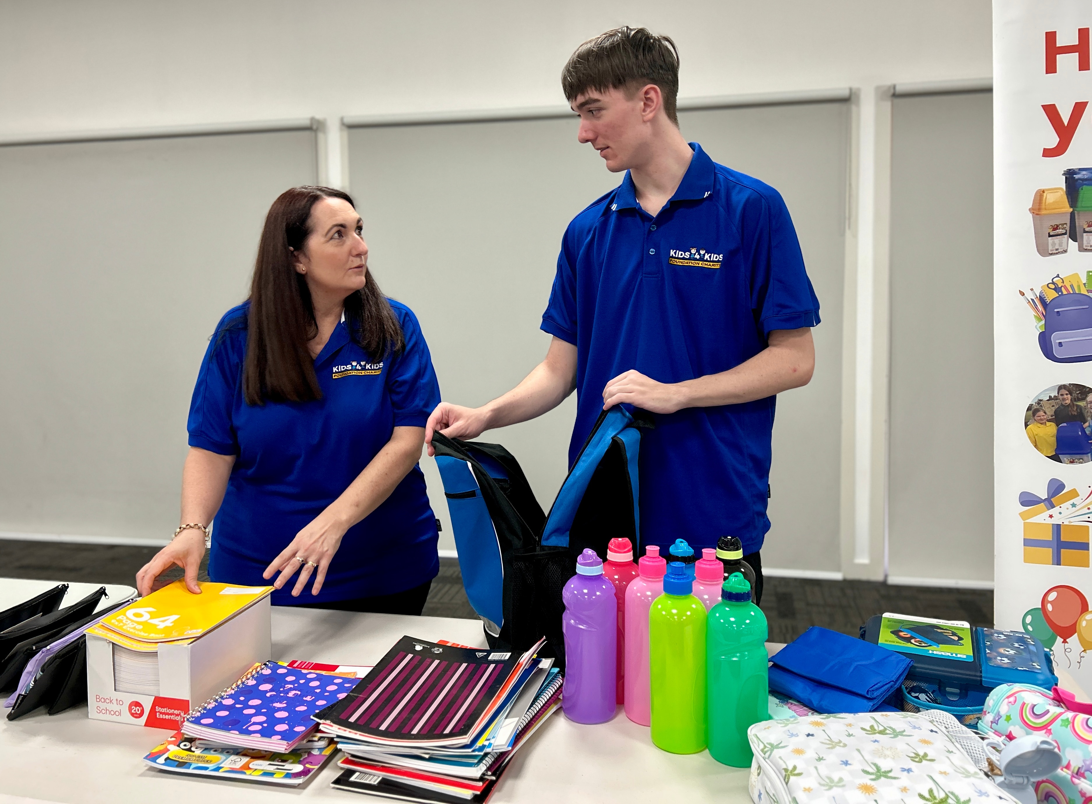 duas pessoas com camisas azuis fazendo uma mala