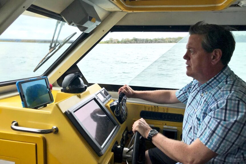 Tim Nicholls takes the wheel of a boat off Victoria Point on Brisbane's bayside during the 2017 election campaign.