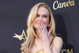 Nicole Kidman arrives on the red carpet for the American Film Institute Lifetime Achievement Awards.  in a gold sparkly dress