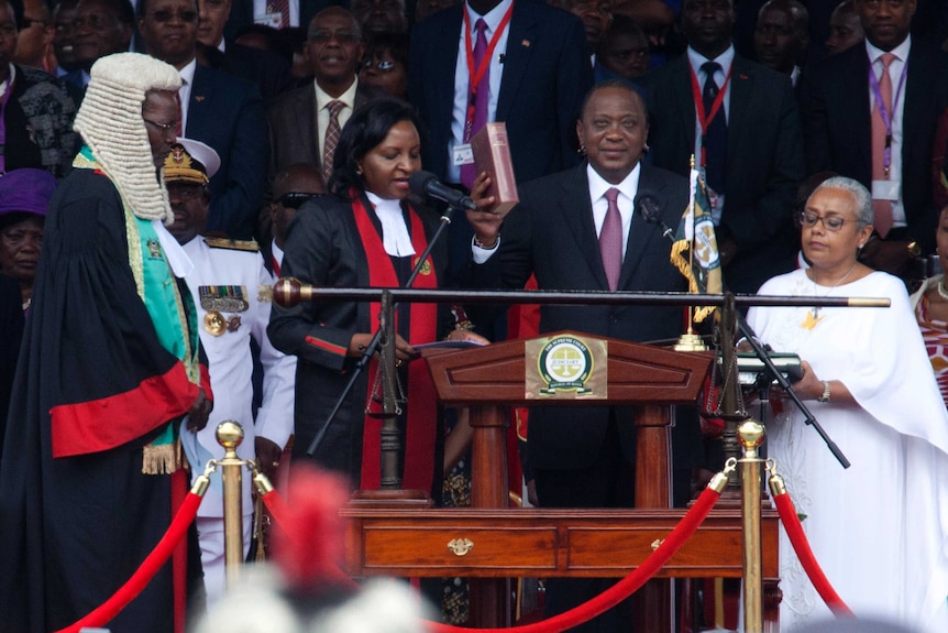 Kenyan President Uhuru Kenyatta, centre, holds a bible at his inauguration ceremony.
