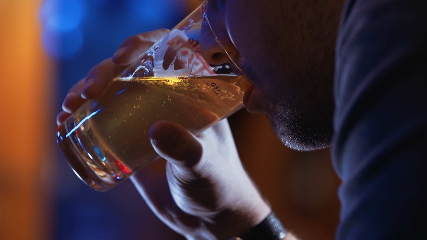 A man drinking beer in a bar.