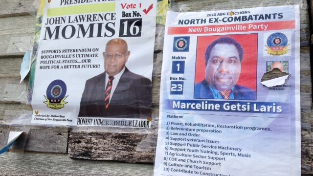 Election posters tacked onto a timber wall