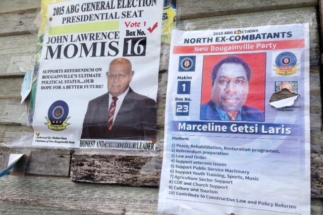 Election posters tacked onto a timber wall