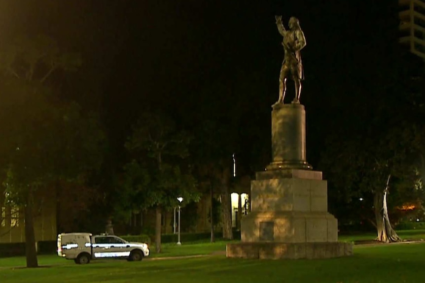 A split of two police cars parked near two monuments