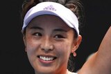 A tennis player smiles and waves at the crowd after beating a top player at the Australian Open.
