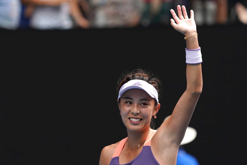 A tennis player smiles and waves at the crowd after beating a top player at the Australian Open.