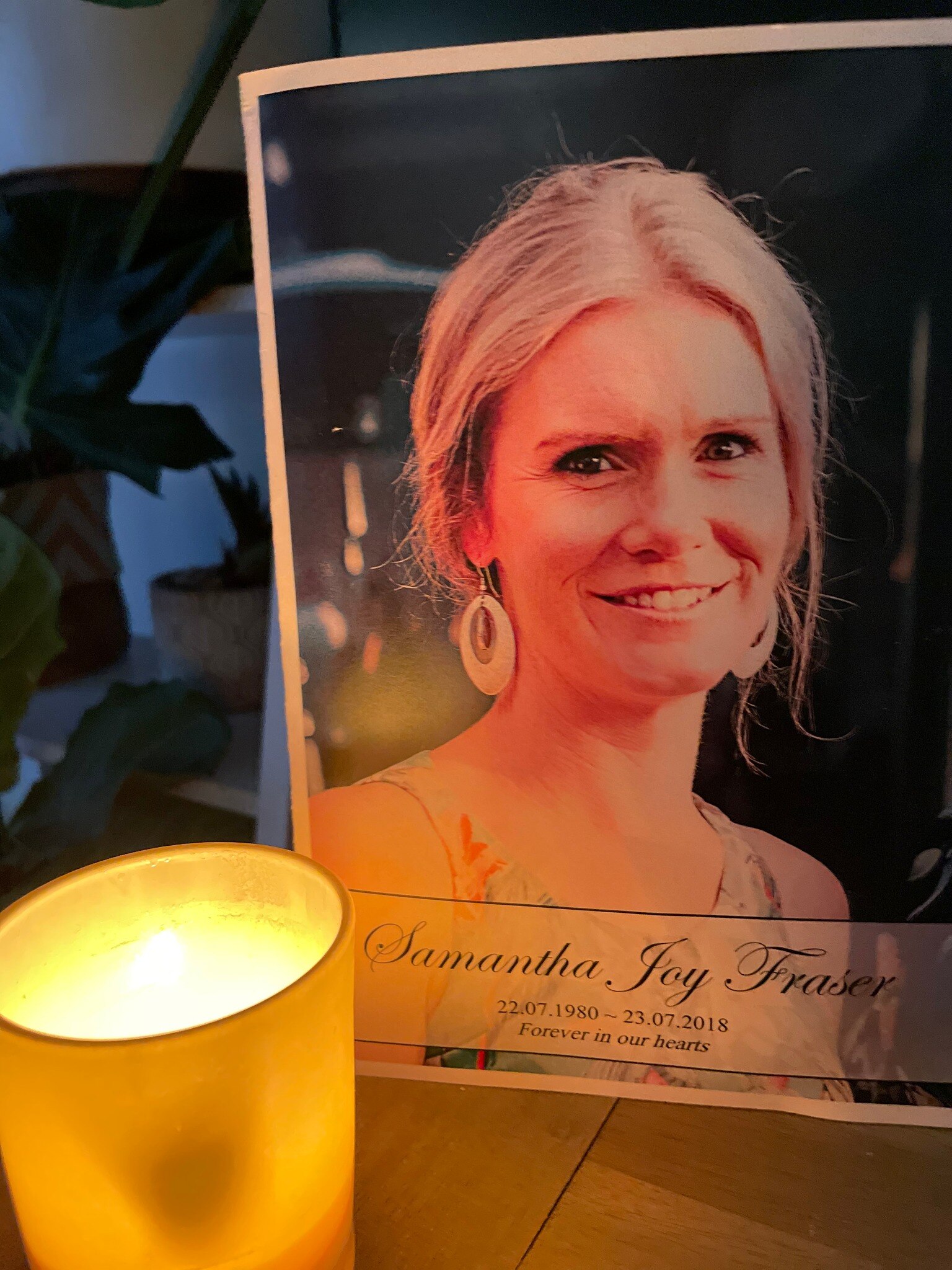 A candle burns in front of a photo of Samantha Fraser.