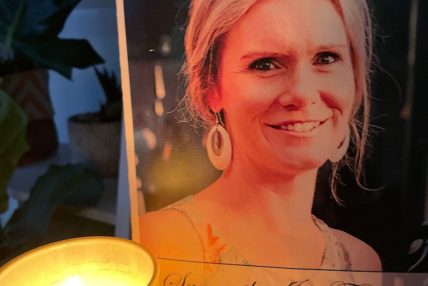 A candle burns in front of a photo of Samantha Fraser.
