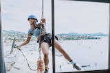 Skye-Blue Henderson hanging off ropes cleaning windoww