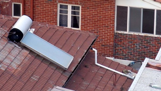 A solar hot water system sits on a roof
