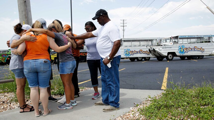 People pray outside Ride the Ducks, an amphibious tour operator involved in a boating accident on Table Rock Lake.