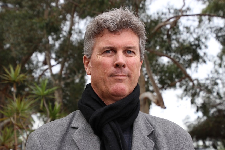 A head and shoulders shot of UWA professor Benjamin Reilly wearing a grey coat and black scarf.