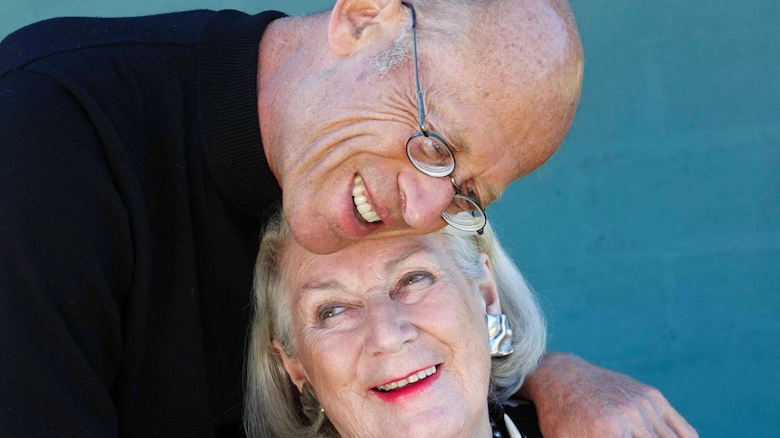An older man and woman having an embrace.
