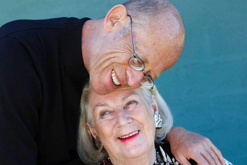 An older man and woman having an embrace.