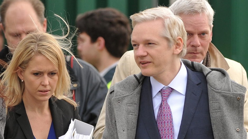 Julian Assange arrives at court in London, flanked by his lawyer