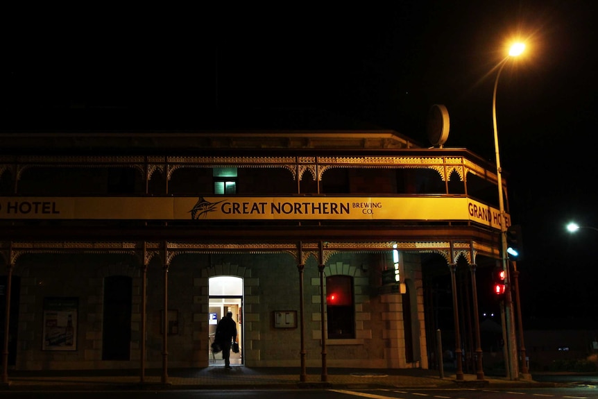 A man enters a hotel at night