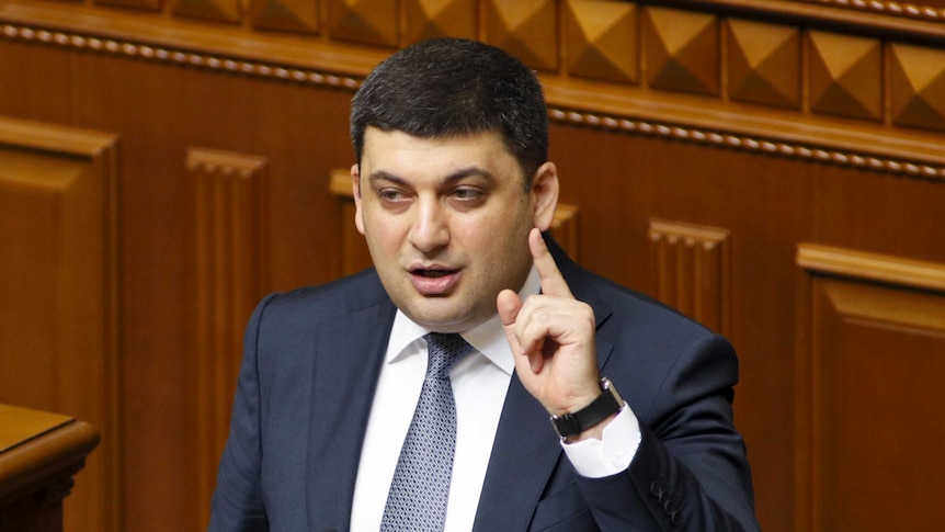 Ukrainian Parliament Speaker Volodymyr Groysman raises a hand while speaking.
