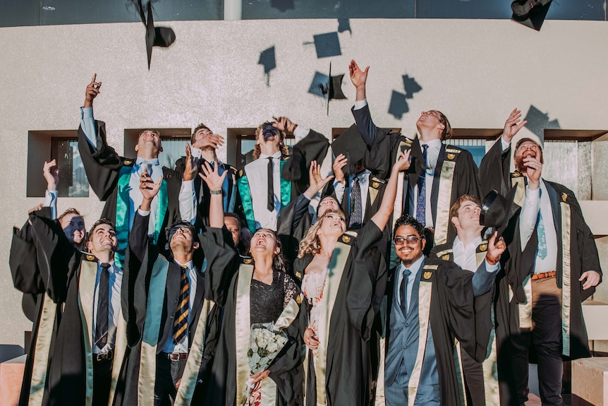University students throw hats in the air.