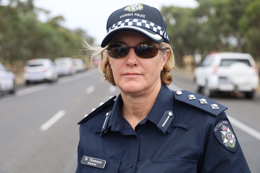 A police woman wearing her blue work uniform wearing glasses