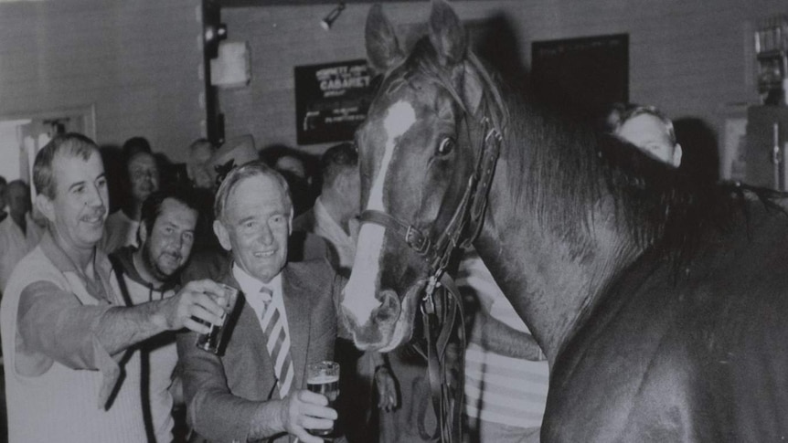 Trainer Cliff Fenwick offers Lord Reims a drink at the front bar of the Morphett Arms.