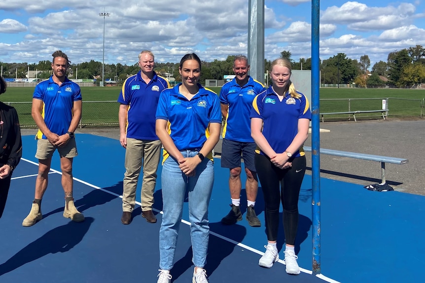 Five members of the Golden Square Football Netball Club standing on a netball court.